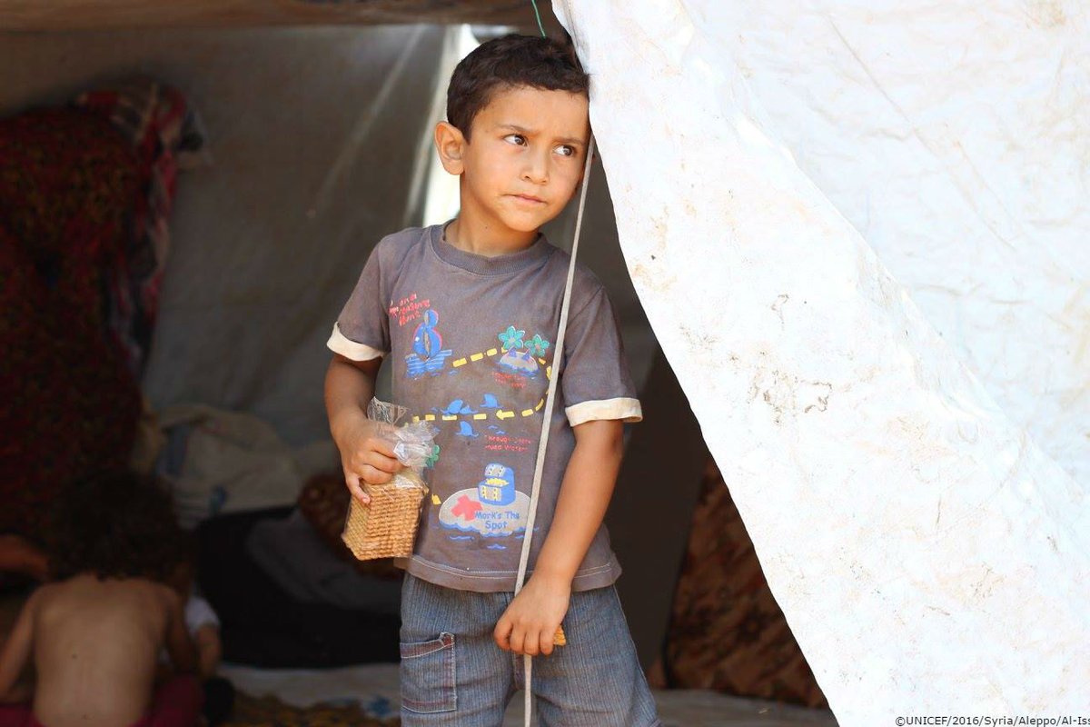A displaced boy stands inside his makeshift tent in the embattled city of #Alepp…