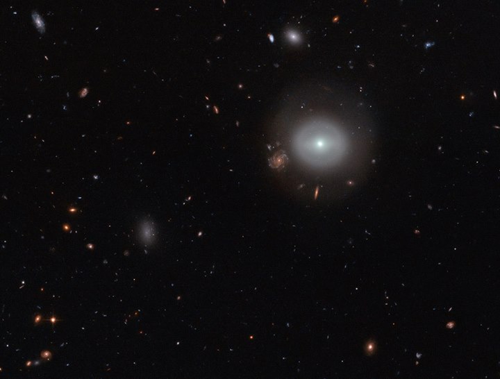 A lone source shines out brightly from the dark expanse of deep space, glowing s…