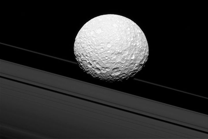Saturn’s moon Mimas looks as if it’s crashing through the ri…