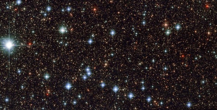 Deep red and bright blue stars are scattered across the fram…